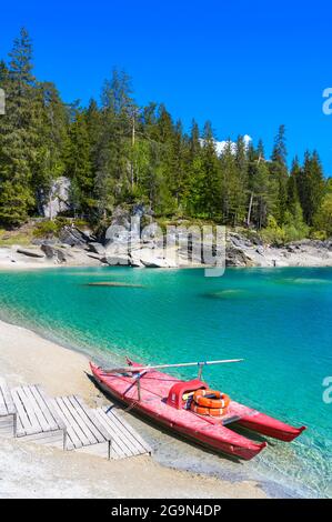 Barca sulla riva del lago Cauma (Caumasee) con acque cristalline in uno splendido paesaggio montano a Flims, Graubuenden - Svizzera Foto Stock