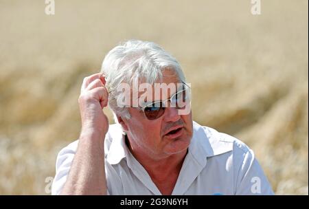 Seltz, Germania. 27 luglio 2021. Detlef Kurreck, presidente dell'Associazione degli agricoltori del Mecklenburg-Vorpommern, parla in un campo di grano maturo presso l'azienda agricola Cord Müller-Scheeßel durante la tradizionale conferenza stampa sulla raccolta dell'associazione degli agricoltori statali. Gli agricoltori del Meclemburgo-Pomerania occidentale si aspettano quest'estate un raccolto medio di cereali e colza. Credit: Bernd Wüstneck/dpa-Zentralbild/dpa/Alamy Live News Foto Stock