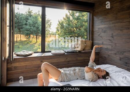 Donna si sveglia in casa di campagna in natura Foto Stock