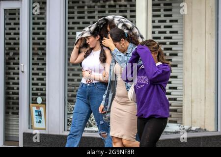 Abiti estivi sotto la pioggia a Preston, Lancashire. Meteo Regno Unito Luglio, 2021. Negozi, negozi e docce a Fishergate. Credit: MediaWorldImages/AlamyLiveNews Foto Stock