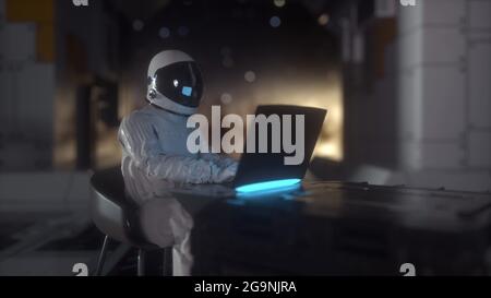 Astronauta lavora sul suo computer portatile della scienza in futuristica astronave, stanza. rendering 3d Foto Stock