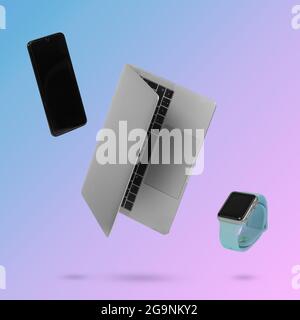 Computer portatile, smartphone e orologio intelligente mentre si levita in aria su uno sfondo illuminato da una sfumatura di colore blu e rosa. Mini creativo Foto Stock