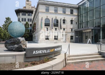 ASHEVILLE, NC, USA-22 LUGLIO 2021: L'Asheville Art Museum, che mostra l'ingresso dell'edificio, lo spazio pubblico, il segno, la palla di vetro e la scultura di roccia. Foto Stock