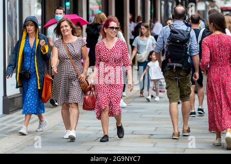 Londra, Regno Unito. 27 luglio 2021. La gente fuori shopping in Regent Street. Secondo una nuova analisi condotta da Huq Industries, un’azienda di ricerca sulla mobilità, l’app Covid del Regno Unito ‘pingdemic’ sta causando un significativo rallentamento delle persone che si spostano e visitano i negozi. In tutto il Regno Unito nel mese di luglio, la percentuale media di vendite al dettaglio è scesa del 2.83% e la mobilità del 5.5%. Credit: Stephen Chung / Alamy Live News Foto Stock