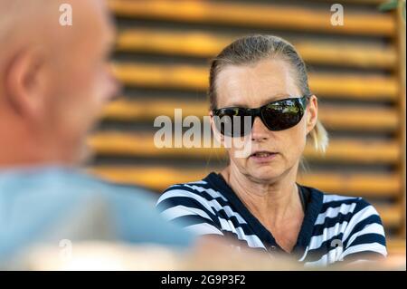 coppia di mezza età che si rilassa insieme in giardino e parla, ritratto closeup di una donna Foto Stock