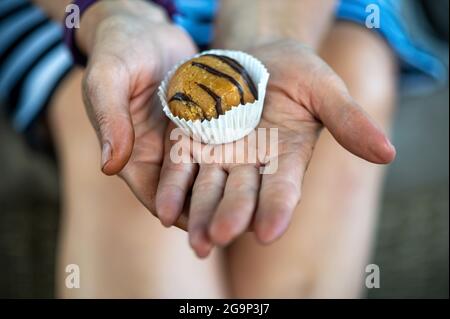 mani donna che danno dolce torta con cioccolato, closeup Foto Stock