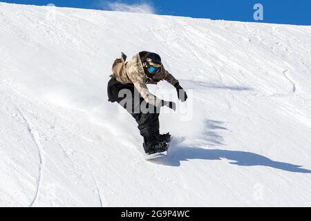 Snowboarder in azione in pista con neve fresca Foto Stock