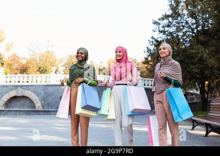 Gruppo di donne musulmane fare shopping Passeggiate portare borse all'aperto Foto Stock