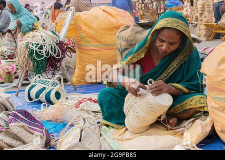 KOLKATA, BENGALA OCCIDENTALE , INDIA - 23 NOVEMBRE 2014 : Unidentified Indian woman making handmade jute bags, Artigianato on durante la Fiera dell'Artigianato a Kolk Foto Stock