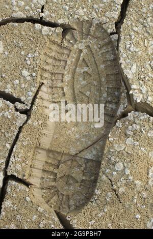 ingombro elevato su una sabbia fangosa di uno scarpone maschio Foto Stock