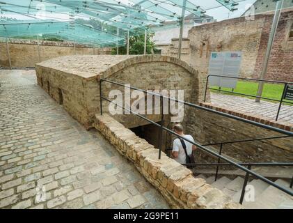 Speyer, Germania. 27 luglio 2021. Un uomo entra nell'edificio della mikvah, che fu costruito nel 1120 in stile architettonico romanico. Il bagno rituale ebraico con una piscina a tuffo a circa dieci metri sotto il livello della strada di oggi nel suo stile architettonico monumentale è considerato il più antico mikvah conosciuto del suo genere. Per la prima volta, l'UNESCO ha designato i beni culturali ebraici in Germania come siti Patrimonio dell'Umanità, con l'ambito premio destinato ai cosiddetti siti Shum di Magonza, Worms e Speyer come culla dell'ebraismo europeo. Credit: Frank Rumpenhorst/dpa/Alamy Live News Foto Stock