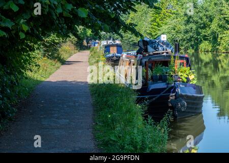 chiatte di canale o barche strette ormeggiate sul torreggiante del canale di bridgewater tra la vendita e greater manchester in un giorno estivo. Foto Stock