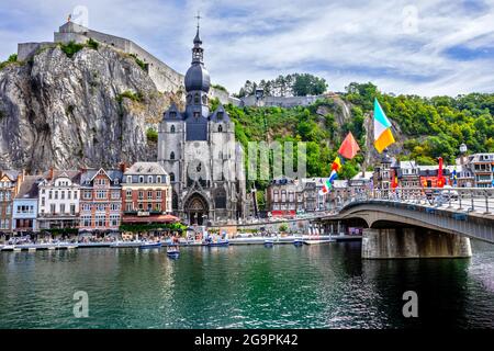 ADinant, Belgio - 19 luglio 2020: La città storica di Dinant con la bandiera belga e la cittadella sulla roccia e Collegiata di Notre-Dame Foto Stock