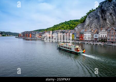 Dinant, Belgio - 19 luglio 2020: La città storica di Dinant. Barca turistica con bandiera belga sul fiume Mosa, Vallonia, Belgio Foto Stock