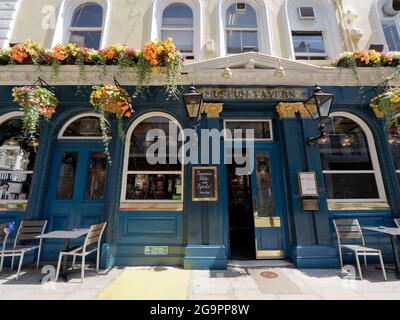 Londra, Greater London, England, 17 2021 luglio: Ingresso alla Greene King Museum Tavern di Bloomsbury con cestini di fiori appesi e tavolo e c Foto Stock