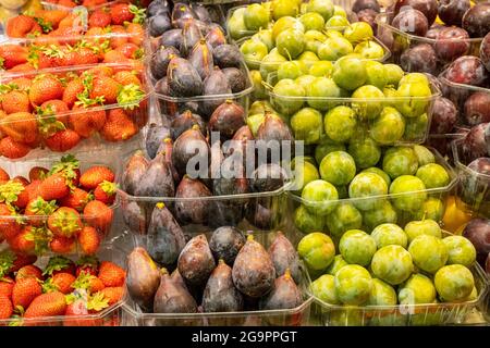 Prugne, fragole e fichi da vendere in un mercato Foto Stock