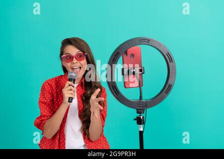 lezione di esercitazione vocale online. happy teenage cantante ragazza usare selfie led. kid musica blogger. Foto Stock