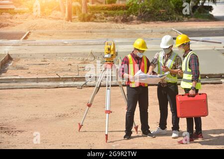 Surveyor ingegnere lavoratore di misurazione con teodolite su strada works.Survey ingegnere in cantiere. Foto Stock