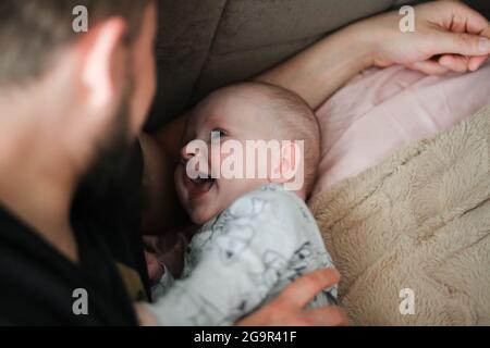 Padre e bambino sorridendo sdraiati sul letto Foto Stock