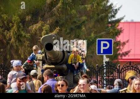 Omsk, Russia. 9 maggio 2021. Dopo la sfilata, i bambini salirono sul cannone militare da 1941-1945 anni. Sfilata russa di attrezzature militari in h Foto Stock