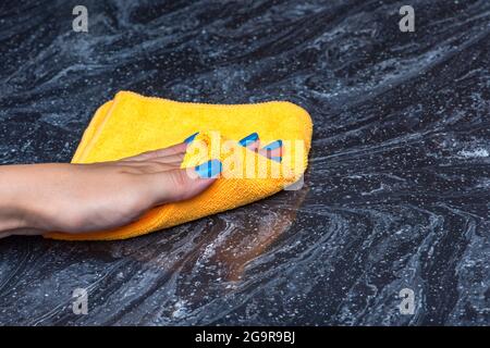 Pulizia del piano di lavoro. Cura per i countertops nella cucina o nel bagno. Pulizia di superfici in pietra, marmo o pietra artificiale. Foto Stock