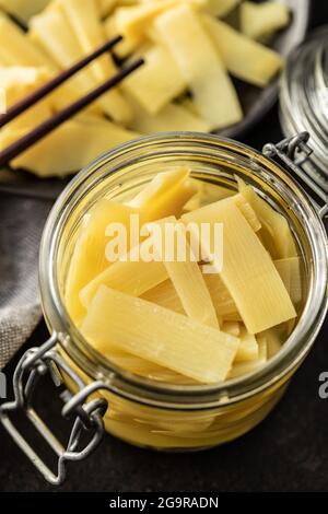 Germogli di bambù in scatola a fette in vaso su tavolo da cucina. Foto Stock