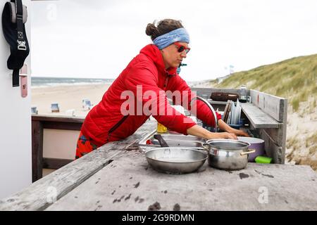 Kampen, Germania. 19 luglio 2021. Il bagnino Jana Kubikova lava i piatti dietro la stazione di bagnino. (A dpa 'il bagnino Kubikova vigila sulla vita dei bagnanti') Credit: Frank Molter/dpa/Alamy Live News Foto Stock