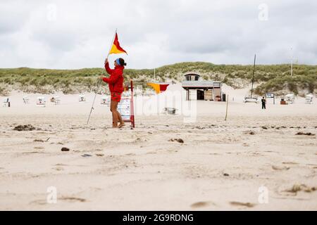 Kampen, Germania. 19 luglio 2021. Il bagnino Jana Kubikova inizia la sua giornata lavorativa segnando la zona di balneazione. Credit: Frank Molter/dpa/Alamy Live News Foto Stock