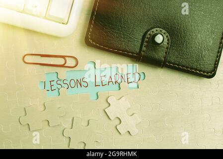 Lezioni apprese con il segno della scrittura a mano. Parola per la conoscenza o la comprensione acquisita da esperienza costruire un puzzle bianco incompiuto Jigsaw modello Foto Stock