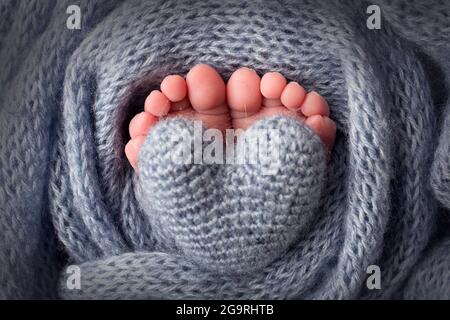 I piedi del bambino in una morbida coperta di lana blu chiaro. Punte piccole. Foto Stock