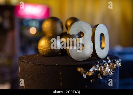 Torta di compleanno numero 30 stelle cielo e concetto di luna, candela blu è fuoco da accendino. CopySpace sul lato destro dello schermo. Vista ravvicinata Foto Stock