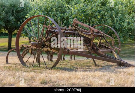 Le vecchie attrezzature rustiche della fattoria si trovano abbandonate in un campo in BC, Canada. Vista sulla strada, foto di viaggio, concept foto d'epoca. Foto Stock