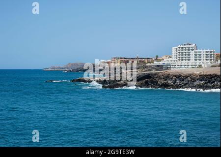 Estate, viste limpide verso San Blas e Golf del sur, località turistiche con alberghi ed edifici sul lungomare e costa frastagliata da Los Abrigos, Tenerife Foto Stock