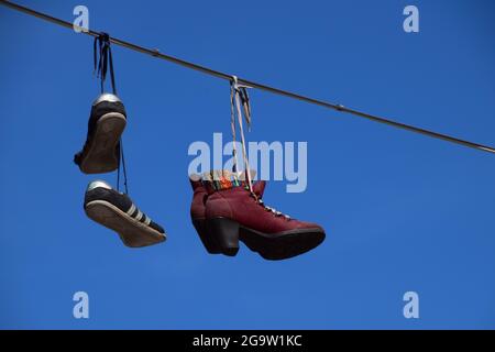 Scarpe su una linea telefonica Foto Stock