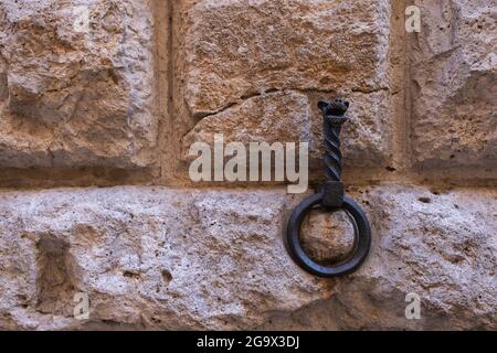 Anello di ferro su muro di pietra per legare il cavallo a Siena, Toscana Foto Stock