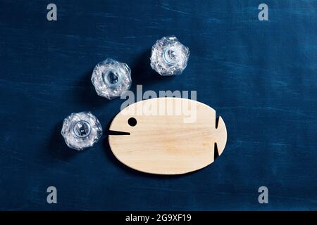 Pesce di legno con bolle di bottiglie d'acqua di plastica. Inquinamento marino o oceanico, conservazione ambientale e microplastica nel concetto alimentare. Foto Stock