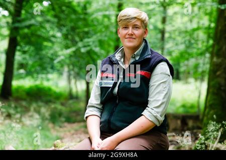 Mittelangeln, Germania. 26 luglio 2021. Antje Andresen, il nuovo direttore di distretto di Satrup delle foreste di Stato di Schleswig-Holstein (SHLF) dal 1° settembre 2021, siede su un tronco di albero e guarda nella macchina fotografica. Credit: Frank Molter/dpa/Alamy Live News Foto Stock