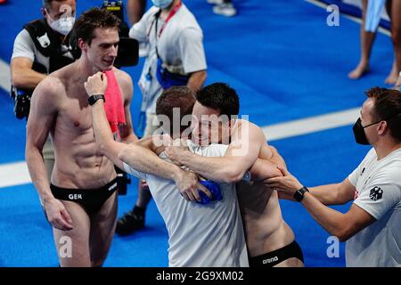 Tokio, Giappone. 28 luglio 2021. Nuoto: Olimpiadi, finali, immersioni in acqua - immersione sincronizzata 3 m, uomini al Tokyo Aquatics Center. Lars Rüdiger (2° da sinistra) e Patrick Hausding (M) dalla Germania festeggiano con i loro allenatori dopo aver vinto la medaglia di bronzo. Credit: Michael Kappeler/dpa/Alamy Live News Foto Stock