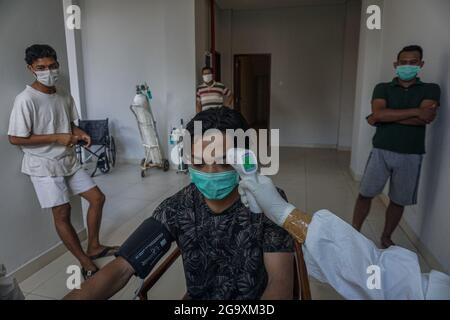 Badung, Indonesia. 27 luglio 2021. I pazienti isolati ottengono il loro controllo medico di routine in su a Wisma Bima Cottages II, Kuta. Il governo locale di Bali ha centralizzato le isolazioni di Covid-19 per i sintomi asintomatici e lievi per facilitare il controllo medico. Prima che migliaia di persone morivano durante l'auto-quarantena nelle loro case, sulla base dei dati del Ministero della Salute dell'Indonesia. Credit: SOPA Images Limited/Alamy Live News Foto Stock