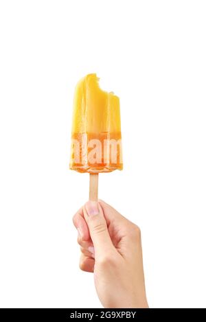 Donna tiene morso gelato giallo su sfondo bianco isolato. Colore popsicle di frutta surgelata. Foto Stock