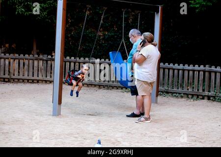 Nonni in un parco con il loro nipote, Barcellona, Spagna. Foto Stock