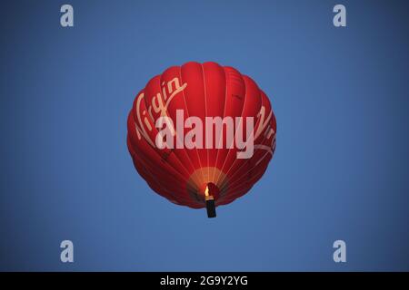 Peterborough, Regno Unito. 26 luglio 2021. Una mongolfiera rossa Virgin vola in alto sopra Peterborough, Cambridgeshire, UK, il 26 luglio 2021 Credit: Paul Marriott/Alamy Live News Foto Stock