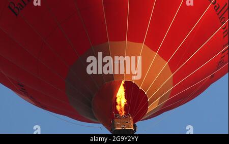 Peterborough, Regno Unito. 26 luglio 2021. Una mongolfiera rossa Virgin vola in alto sopra Peterborough, Cambridgeshire, UK, il 26 luglio 2021 Credit: Paul Marriott/Alamy Live News Foto Stock