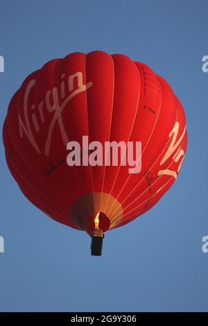 Peterborough, Regno Unito. 26 luglio 2021. Una mongolfiera rossa Virgin vola in alto sopra Peterborough, Cambridgeshire, UK, il 26 luglio 2021 Credit: Paul Marriott/Alamy Live News Foto Stock