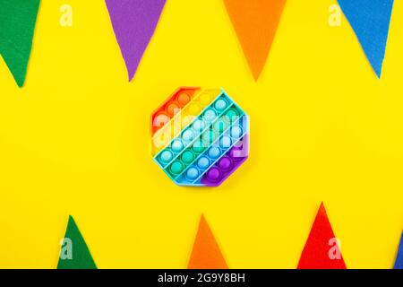 Giocattolo antistress pop it. Fidget sensoriale in silicone arcobaleno su sfondo colorato. Nuovo popolare giocattolo alla moda in silicone. Foto Stock