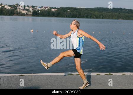 l'uomo anziano è impegnato a correre nell'aria fresca Foto Stock