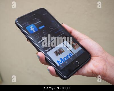 KOLKATA, INDIA - 26 luglio 2021: IPhone 7 più colore nero getto. Giovani Donne con smalto per unghie blu Apri le applicazioni FACEBOOK sullo schermo dell'app store Foto Stock