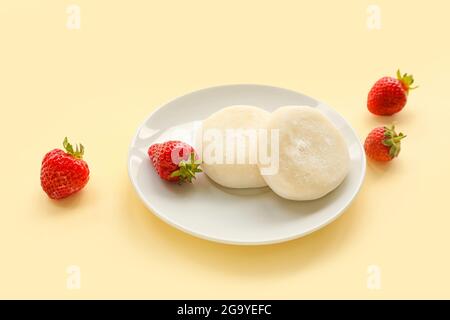 Piatto con gustosi mochi giapponesi e fragola su sfondo colorato Foto Stock