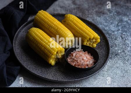 Piatto di pannocchie di mais con sale rosa dell'himalaya Foto Stock