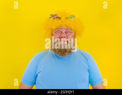 Uomo felice grasso con parrucca in testa e occhiali da sole Foto Stock